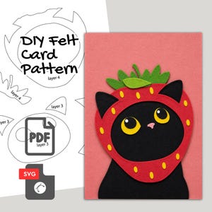 May include: A DIY felt card pattern featuring a black cat wearing a strawberry costume on a pink background. The design includes a PDF and SVG file icon, with text reading DIY Felt Card Pattern, layer 4, and layer 3, showing cut-out shapes.