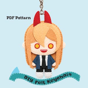 May include: A felt keychain featuring a character with blonde hair, red horns, yellow eyes, and sharp teeth. The character wears a blue jacket, white shirt, and black tie. Text reads PDF Pattern and DIY Felt Keychain on a light blue background.