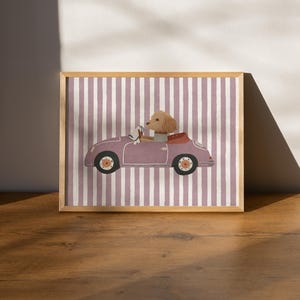 Könnte beinhalten: Gerahmter Druck mit einer Illustration eines Hundes, der ein Oldtimer-Cabrio fährt. Das Auto hat eine gedämpfte lila Farbe, vor einem gestreiften Hintergrund. Der Rahmen hat einen natürlichen Holzton und verleiht dem Kunstwerk einen klassischen Touch.