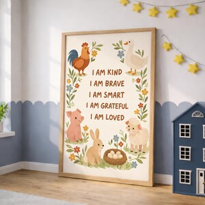 May include: A framed print featuring a rooster, goose, pig, rabbit, and sheep with the text "I AM KIND, I AM BRAVE, I AM SMART, I AM GRATEFUL, I AM LOVED." The artwork has a light wood frame and is decorated with floral elements.