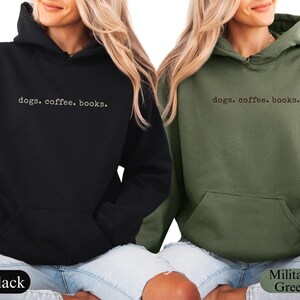 May include: Black and military green hoodies with the text "dogs. coffee. books." printed in a simple font. The hoodies have a front pocket and a hood. The models are wearing blue jeans.