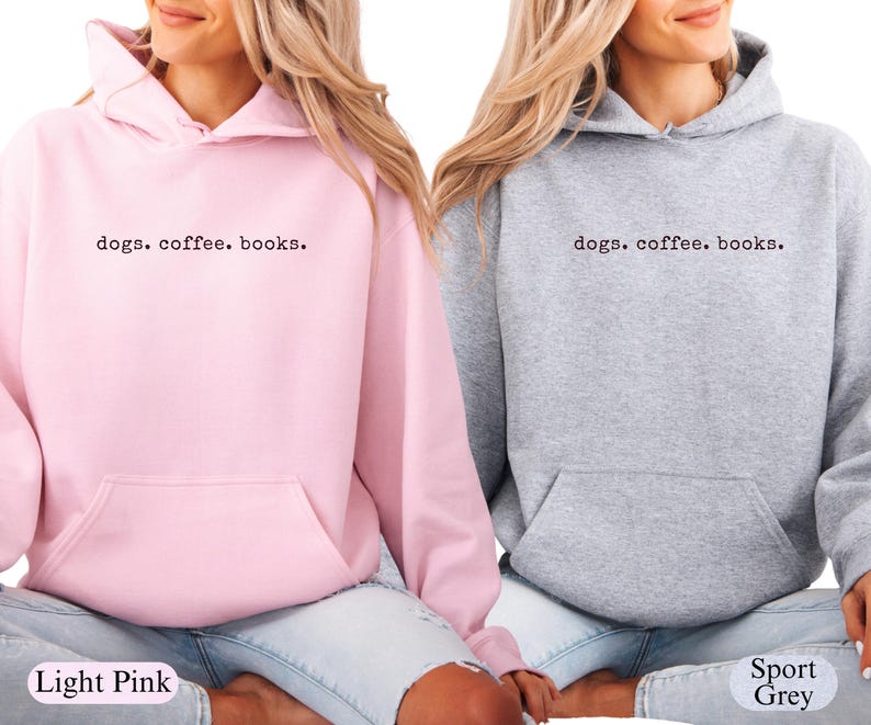 May include: Light pink and sport grey hoodies with the text "dogs. coffee. books." printed in black. The hoodies have a front pocket and a hood with drawstrings. The light pink hoodie is on the left, and the sport grey hoodie is on the right.