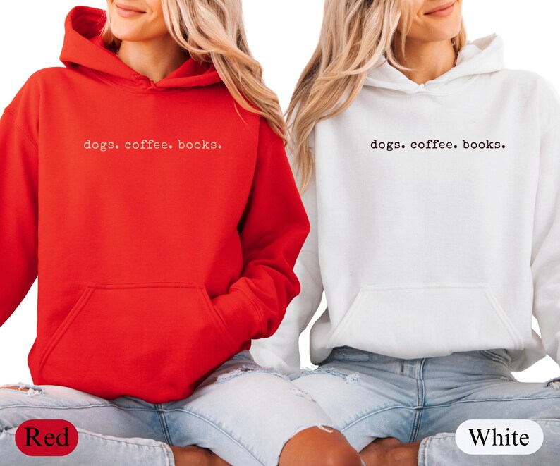 May include: Two hooded sweatshirts, one red and one white, with the text "dogs. coffee. books." printed in a small, centered font. Both sweatshirts have a front pocket and are worn with blue jeans.