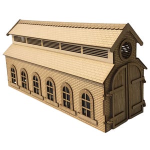May include: A detailed wooden model of a building, featuring a light brown brick effect. It has arched windows, a gabled roof, and a large double door. The model, likely a station or similar, is made from wood.