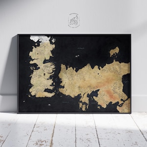 May include: A framed map of a fictional world, featuring landmasses in tan and brown against a black background. The map is detailed with geographical features and place names. The frame is black, and the print is displayed on a white wooden floor.