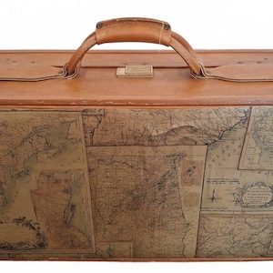 May include: A rectangular tan suitcase featuring a vintage map print across the front panel. The suitcase has a sturdy top handle, a metal latch closure, and smooth, worn edges. The map design displays geographical details and cartographic text.