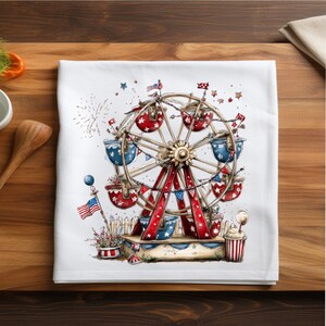 May include: A white kitchen towel featuring a watercolor illustration of a Ferris wheel with red and blue passenger cars, decorated with stars and stripes. The scene includes a small American flag, fireworks, and a striped popcorn container.
