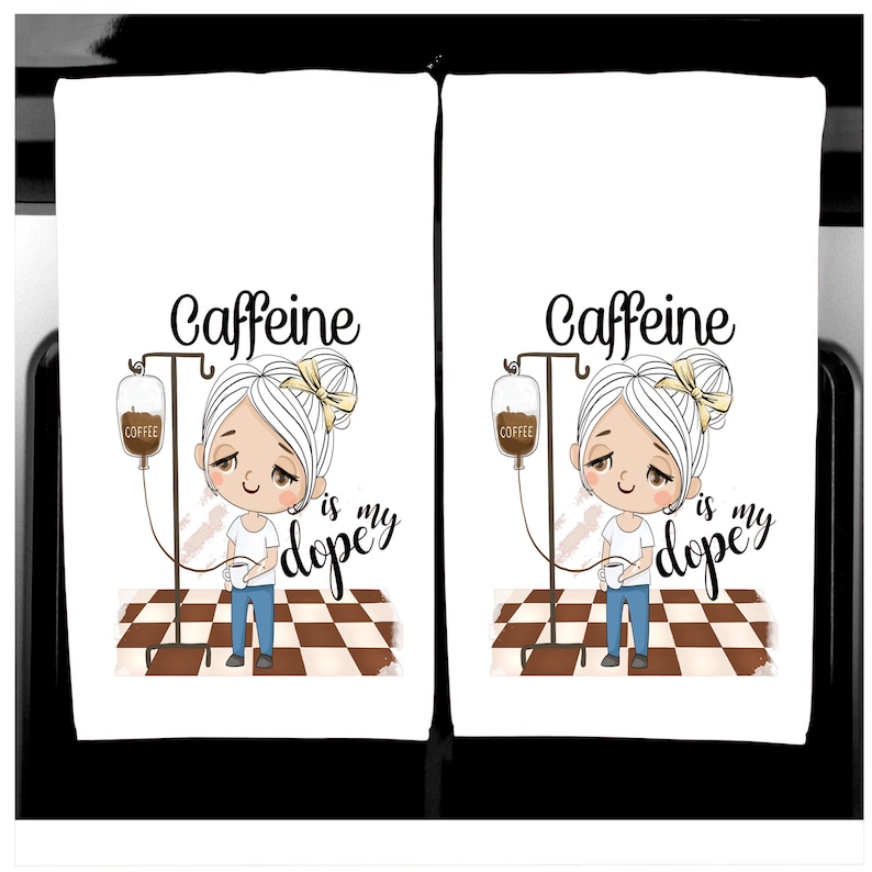 K&ouml;nnte beinhalten: Zwei wei&szlig;e K&uuml;chent&uuml;cher mit einer Cartoon-Illustration. Das Design zeigt ein M&auml;dchen mit einem Kaffee-IV-Tropf, dem Text "Caffeine is my dopey". Das M&auml;dchen h&auml;lt eine Kaffeetasse und steht auf einem braun-wei&szlig; karierten Boden.