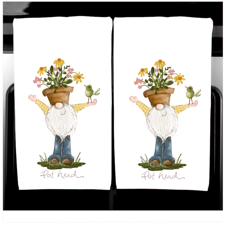 K&ouml;nnte beinhalten: Zwei wei&szlig;e K&uuml;chent&uuml;cher mit einem skurrilen Zwergen-Design. Der Zwerg hat einen Blumentopf als Kopf und h&auml;lt einen Vogel. Der Text "Pot head" steht unten. Der Zwerg tr&auml;gt ein gelb kariertes Hemd und blaue Jeans.