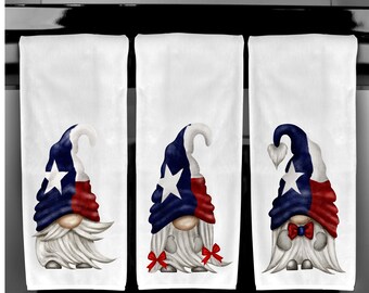 Peut inclure: Trois torchons de cuisine blancs avec des motifs de gnomes. Chaque gnome porte un chapeau aux couleurs du drapeau du Texas : bleu, blanc et rouge. Les gnomes ont de longues barbes blanches et certains ont des nœuds rouges.