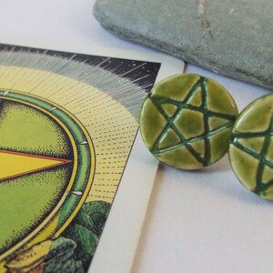 May include: A pair of green ceramic earrings with a five-pointed star design.