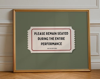 Puede incluir: Una impresión enmarcada con un borde dorado y un fondo verde. La impresión presenta un diseño blanco en forma de boleto con el texto "PLEASE REMAIN SEATED DURING THE ENTIRE PERFORMANCE" y "NO EXCEPTIONS" en negro.
