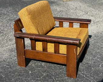 May include: A vintage wooden armchair with a brown frame and a yellow woven fabric seat and back.