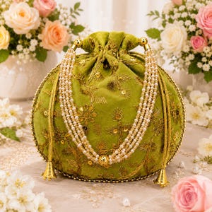 以下が含まれることがあります： ライムグリーンのベルベット製巾着バッグ。金糸の複雑な刺繍とメタリックなスパンコールが施され、小さな白いフェイクパールを連ねた多重ストラップが付いています。バッグは丸みを帯びた形状で、底面にはゴールドトーンの金属製アクセントがあしらわれています。