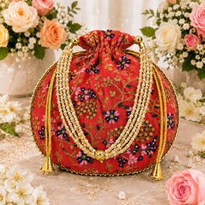May include: A red drawstring pouch bag featuring an intricate floral embroidery pattern in pink, blue, and green threads. The bag is adorned with multiple strands of cream-colored faux pearls and gold-toned metallic tassels at the base.