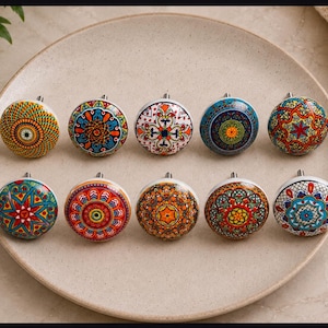 May include: A set of ten round ceramic cabinet knobs arranged in two rows. Each knob features a unique, intricate, and colorful mandala-style pattern with vibrant hues including red, blue, yellow, orange, green, and white, finished with a metallic bolt.