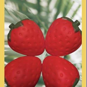 May include: Four bright red strawberry-shaped objects with textured surfaces and small indentations. Each strawberry features a dark green stem at the top. The four items are arranged in a symmetrical square formation against a light background.