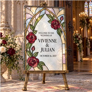 May include: A rectangular wedding welcome sign featuring a stained glass design with red roses and green leaves. The center text reads: WELCOME TO THE WEDDING OF VIVIENNE & JULIAN OCTOBER 16, 2027. The sign is displayed on a metallic tripod easel stand.