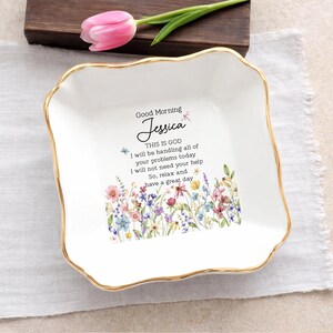 May include: A square white ceramic trinket dish with a scalloped gold rim. The center features a colorful wildflower illustration and the text: Good Morning Jessica, THIS IS GOD, I will be handling all of your problems today, I will not need your help, So, relax and have a great day.