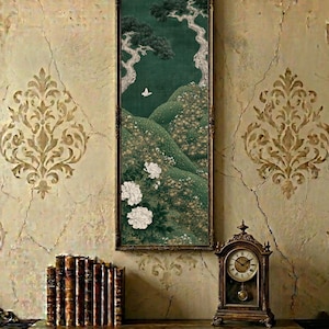 May include: A tall, rectangular wall art piece featuring a dark green landscape with rolling hills, stylized trees, white flowers, and a small white bird. The artwork is enclosed in a thin, dark-toned frame and is displayed on a textured wall.
