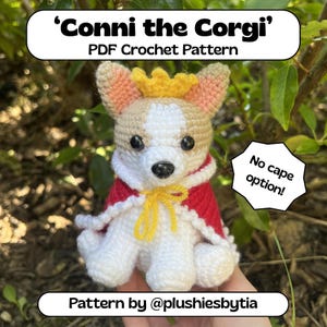 Op de afbeelding: Een gehaakte corgi-hond met een rode cape en een gouden kroon. De hond is wit, bruin en beige. De tekst op de afbeelding luidt "Conni the Corgi" en "PDF Crochet Pattern". Een tekstballon zegt "No cape option!"
