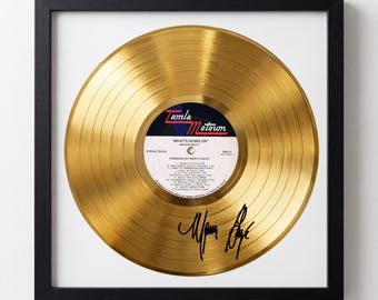 May include: Framed gold record of Marvin Gaye's "What's Going On" album. The record is displayed in a black frame with a white mat. The record label is visible, and the artist's signature is present.
