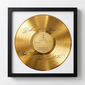 Puede incluir: Disco de oro enmarcado del álbum "Ship Ahoy" de The O'Jays. El disco está firmado por Walter L. Williams Sr., Eddie Levert y Sammy Strain. El disco está en un marco negro.