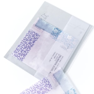 May include: A pack of tracing paper sheets featuring floral and leaf patterns in purple and blue hues. The package includes text that reads "ORIGINAL STATIONERY TRACING PAPER STICKY NOTES" and "YOHAKU, JR. NET". Each sheet measures 70x70mm.