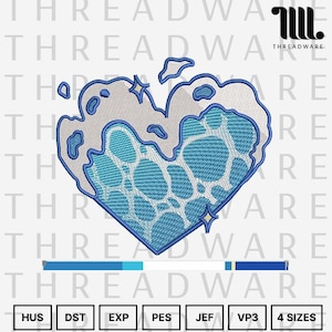 Puede incluir: Un diseño de corazón bordado en azul y blanco. El corazón tiene una apariencia texturizada y burbujeante con un interior azul y un contorno blanco. El diseño incluye acentos de estrellas y el texto "THREADWARE".