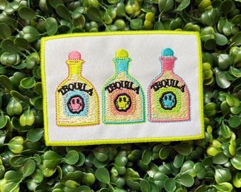 May include: Embroidered patch featuring three tequila bottle designs with the word "TEQUILA" and a smiley face. The bottles are yellow, pink, and blue, with a white background and a neon green border.