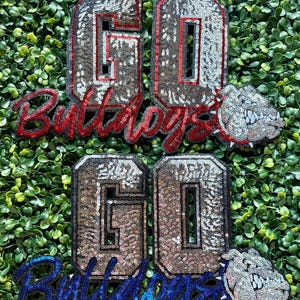 May include: Two sequined patches with the number "60" in silver and red trim, and the word "Bulldogs" in red script. A bulldog mascot is also included. A second set of patches in silver, blue trim, and blue script is also shown.