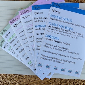 May include: A collection of colorful printed cards with text, arranged in a fan shape. The cards have titles like "Sunday Morning" and "Friday Afternoon." The text includes topics such as "Chairman's Address" and "Feature Bible Drama."