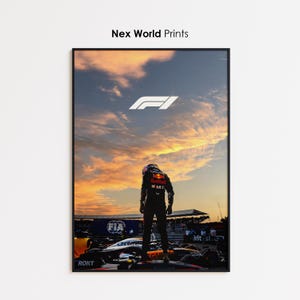 Könnte beinhalten: Gerahmter Druck mit einem Formel-1-Rennwagen und Fahrer vor einem Sonnenuntergangshimmel. Der Druck enthält das F1-Logo und den Text "Nex World Prints". Der Fahrer steht auf dem Auto.