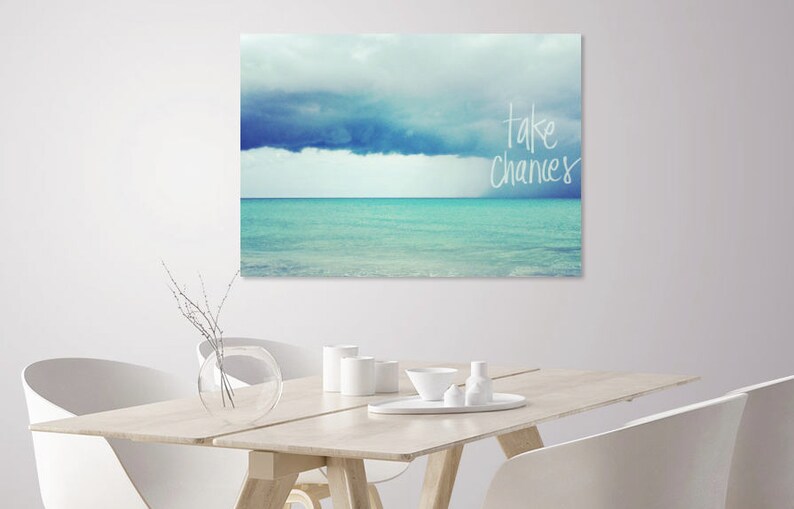 May include: A canvas print with a blue and white seascape and the text "take chances" in white.