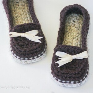 May include: A pair of brown crocheted slippers with white trim and a white satin bow on each slipper.