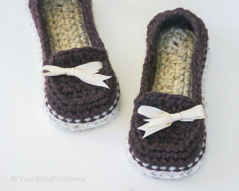 May include: A pair of brown crocheted slippers with white trim and a white satin bow on each slipper.