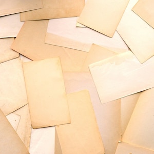 Peut inclure: Une collection de cartes rectangulaires en papier qui se chevauchent dans diverses nuances de beige, de crème et de brun clair. Les cartes sont disposées en un motif dispersé et superposé, créant une surface texturée de papier vierge.