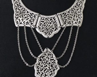 Collar babero estilo vintage en tono plateado, joyería de los años 50 y 60.