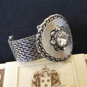 May include: A set of three ceramic mugs with a speckled, matte finish. The mugs are in shades of cream, light gray, and dark gray. Each mug has a simple, minimalist design and a rounded handle.