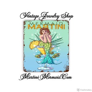 May include: A vintage-style metal sign featuring a mermaid sitting in a martini glass. The sign reads "Mermaid Martini" and "Martini Mermaid.com".