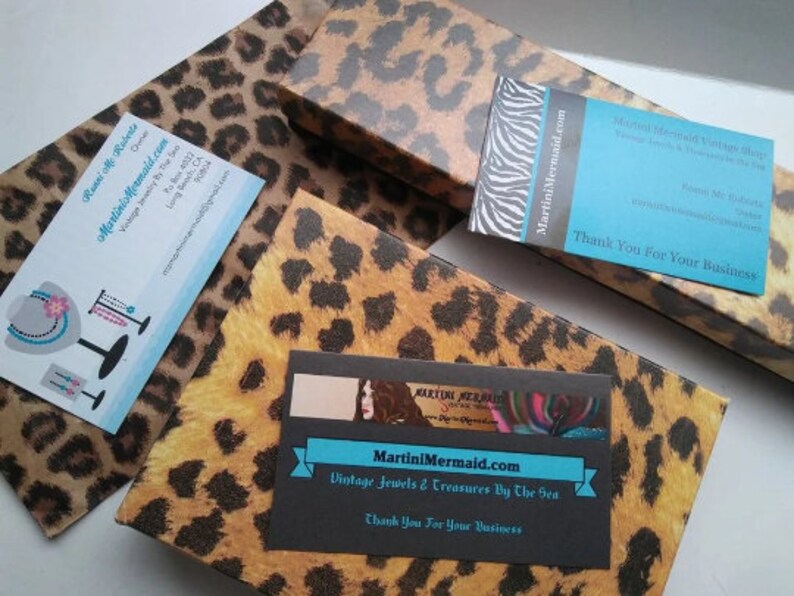May include: Two business cards with a leopard print background. The top card says "Martini Mermaid Vintage Jewelry" and the bottom card says "MartiniMermaid.com Vintage Jewels & Treasures By The Sea". Both cards have the text "Thank You For Your Business".