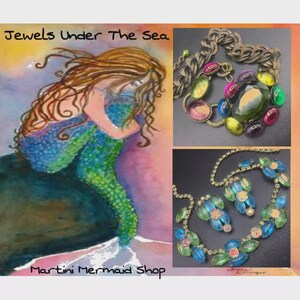 Puede incluir: Imagen que presenta una pintura a la acuarela de una sirena y dos joyas. La sirena tiene cabello largo casta&ntilde;o y una cola azul y verde. Las joyas incluyen un collar y un conjunto de collar y aretes con piedras coloridas. El texto dice "Jewels Under The Sea" y "Martini Mermaid Shop."