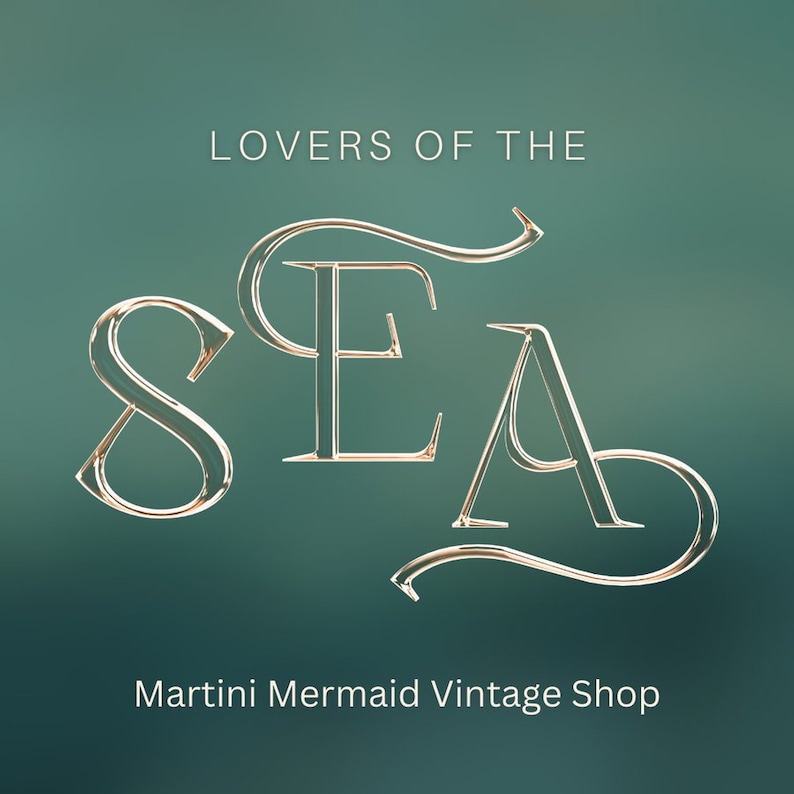 May include: A logo for a vintage shop called "Lovers of the Sea" with the word "SEA" in a stylized font. The text "Martini Mermaid Vintage Shop" is below the logo.
