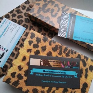 May include: Two business cards with a leopard print background. The top card says "Martini Mermaid Vintage Jewelry" and the bottom card says "MartiniMermaid.com Vintage Jewels & Treasures By The Sea". Both cards have the text "Thank You For Your Business".