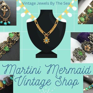 May include: A vintage jewelry shop called "Martini Mermaid Vintage Shop" with a variety of necklaces, bracelets, and earrings featuring green and blue gemstones. The shop's name is written in a decorative font.
