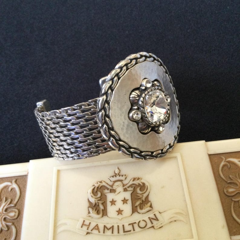 May include: A set of three ceramic mugs with a speckled, matte finish. The mugs are in shades of cream, light gray, and dark gray. Each mug has a simple, minimalist design and a rounded handle.