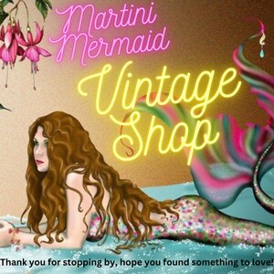 Może przedstawiać: Ilustracja syreny z długimi brązowymi włosami i kolorowym ogonem, leżącej w wodzie. Tekst "Martini Mermaid Vintage Shop" jest wyświetlany w neonowym stylu. Obraz zawiera tekst "Thank you for stopping by, hope you found something to love!"