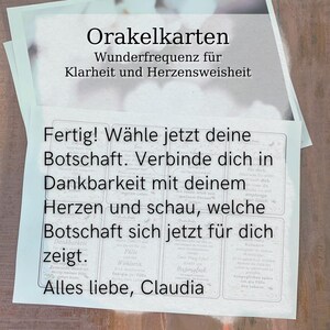 May include: A stack of oracle cards with German text. The top card reads "Orakelkarten" and "Wunderfrequenz f&uuml;r Klarheit und Herzensweisheit." The bottom card has the text "Fertig! W&auml;hle jetzt deine Botschaft. Verbinde dich in Dankbarkeit mit deinem Herzen und schau, welche Botschaft sich jetzt f&uuml;r dich zeigt."