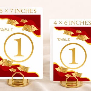 May include: Two table number cards, one 5 x 7 inches and the other 4 x 6 inches, with a gold number 1 inside a gold circle. The cards have a white background with red and gold cloud designs. The word "TABLE" is printed on the cards.
