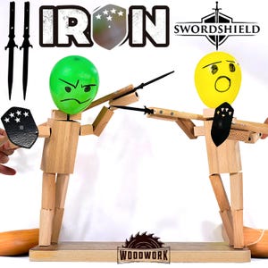 May include: Wooden articulated figures with green and yellow balloon heads, wielding spears and shields. The figures are on a wooden base, with the word "IRON" and "SWORDSHIELD" in the background. The word "WOODWORK" is also visible.